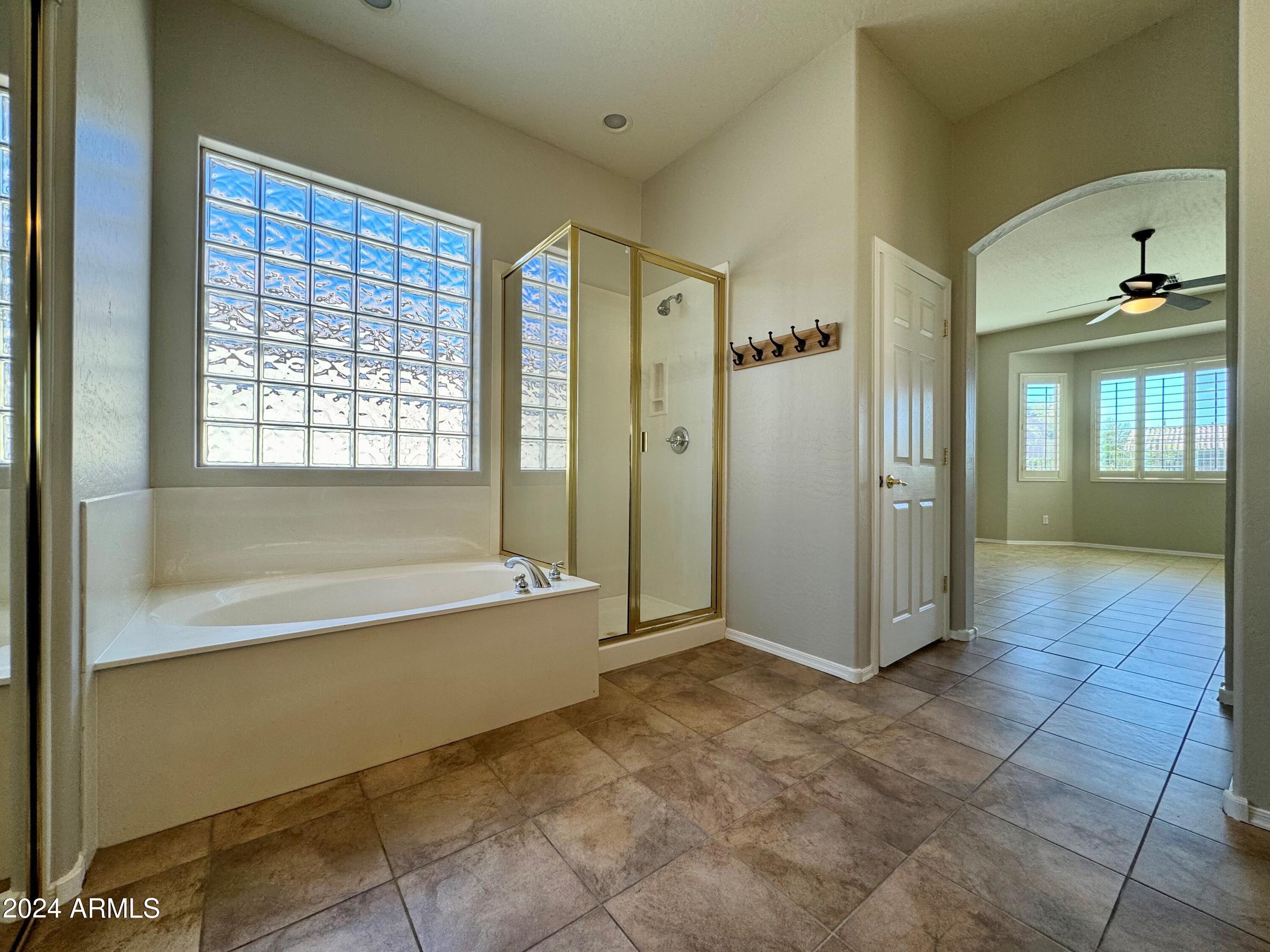 18426 West Piedmont Road Goodyear, AZ 85338 - Photo 22 of 25 a spacious bathroom with a bathtub and a shower