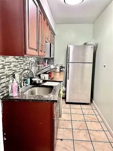a kitchen with a sink a refrigerator and a stove top oven