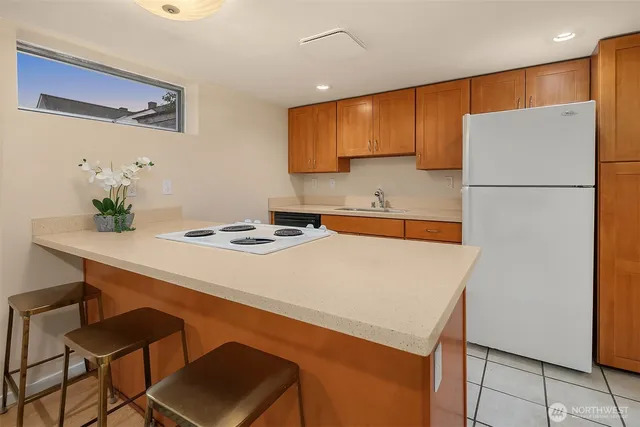 a kitchen with a table chairs refrigerator and sink