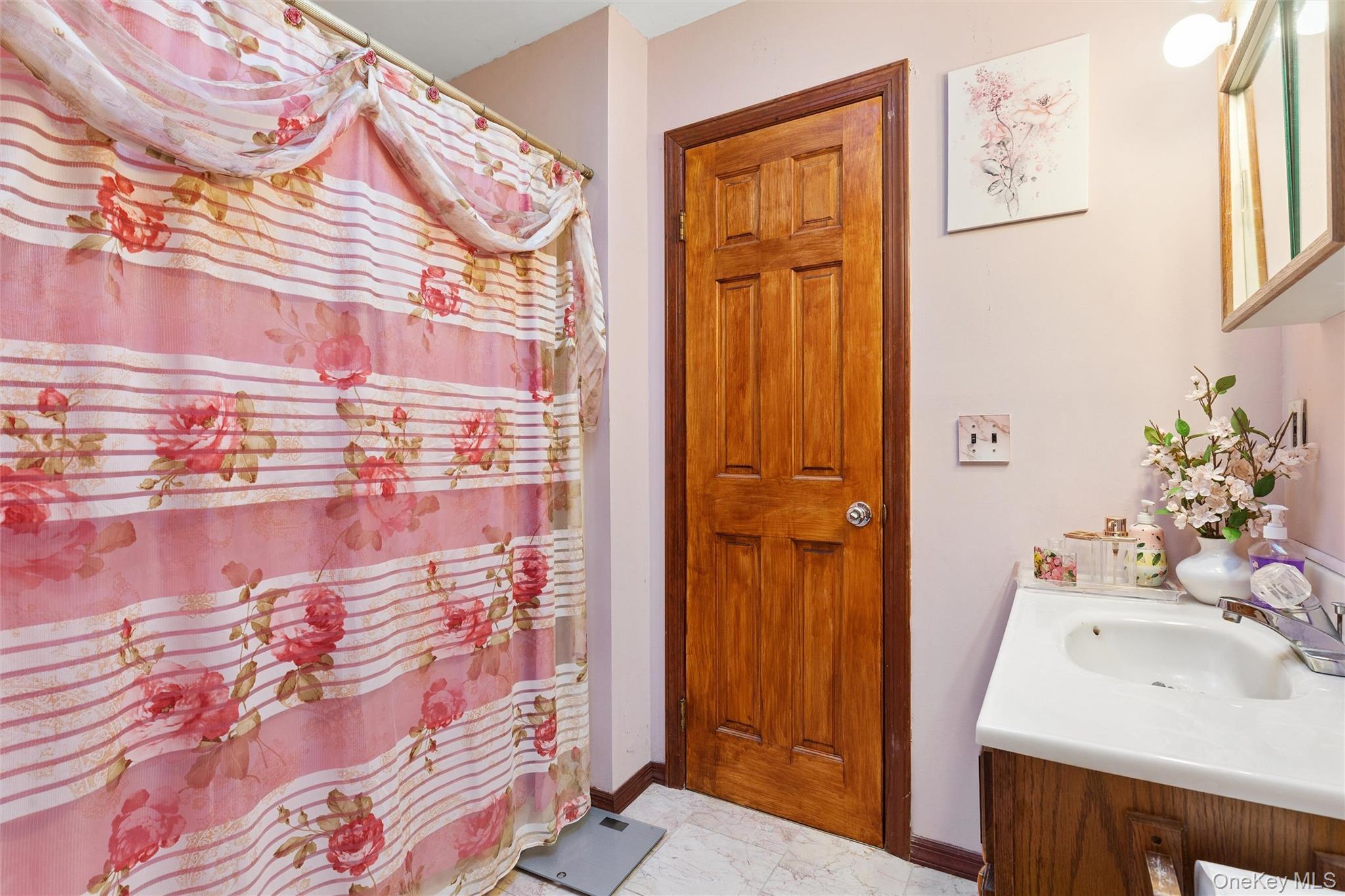 5045 Main Bayview Road Southold, NY 11971 - Photo 14 of 30 a bathroom with a sink and mirror with shower curtain