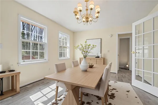 a view of a dining room with furniture a chandelier and wooden floor