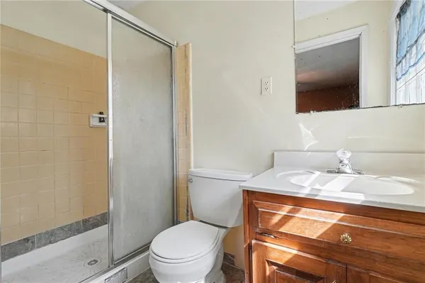 a bathroom with a granite countertop sink toilet a mirror and shower