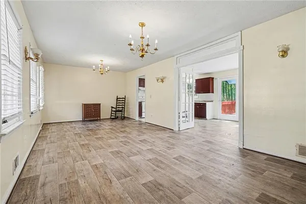 a view of a livingroom with a chandelier fan and wooden floor