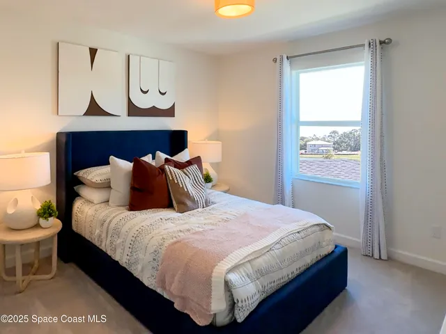 a bedroom with a bed and painting on the wall