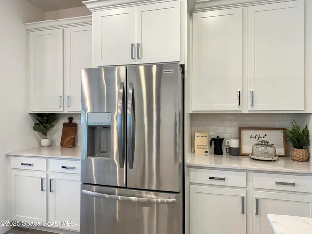 a kitchen with appliances a refrigerator and cabinets