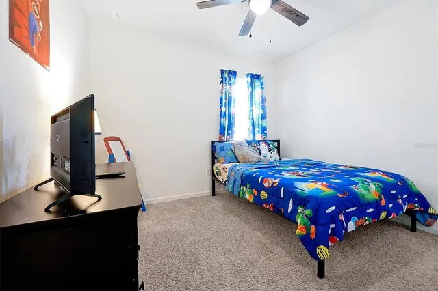 a bedroom with a bed and a flat tv screen on dresser
