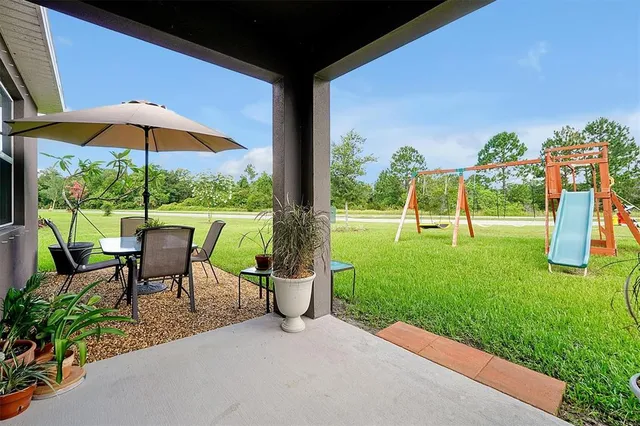 a backyard of a house with table and chairs