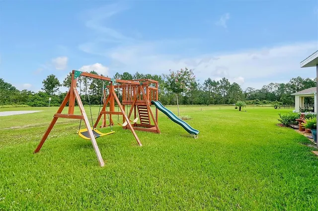a view of a grassy field with trees in the background
