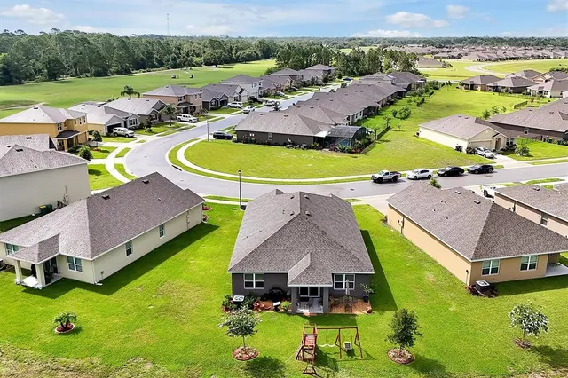 an aerial view of residential houses with outdoor space and pool