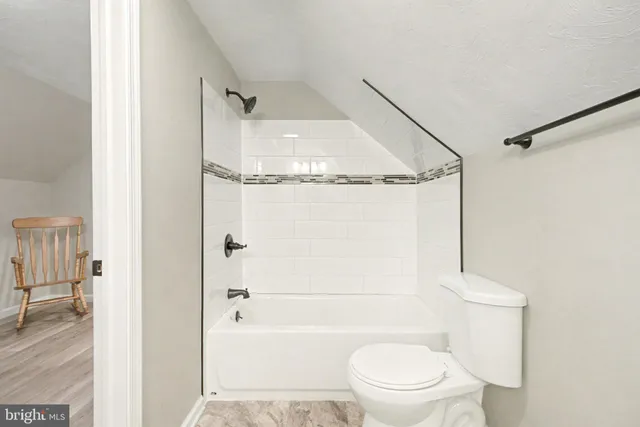 a bathroom with a granite countertop sink mirror vanity and toilet