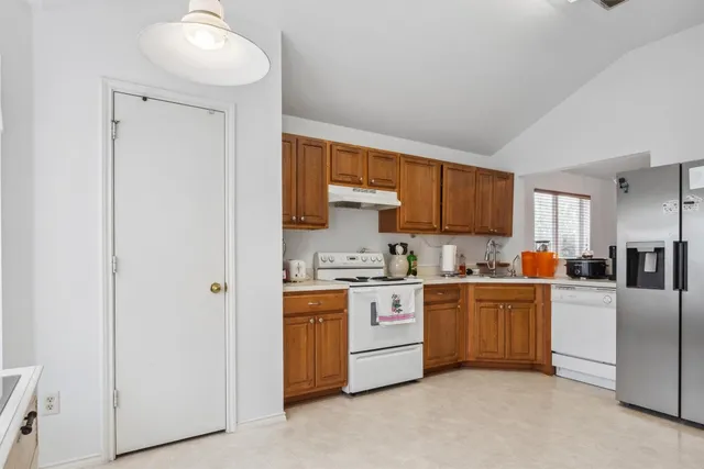 a kitchen with stainless steel appliances granite countertop a stove a sink and a refrigerator