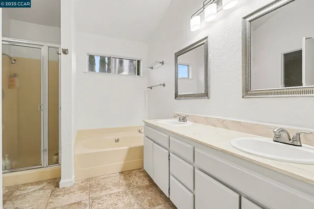 a bathroom with a tub sink and mirror