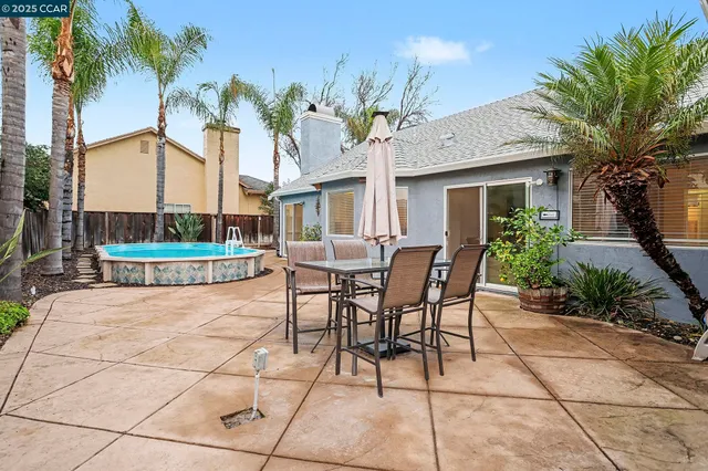 a view of a patio with a table and chairs and potted plants