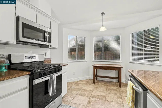 a kitchen with stainless steel appliances granite countertop a stove microwave and sink