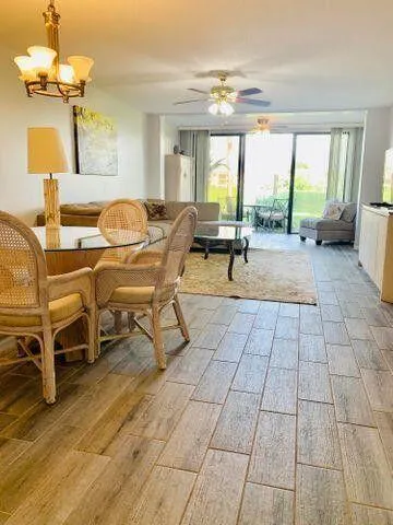 a living room with patio furniture and a large window