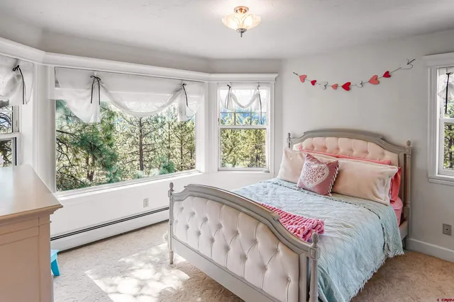 a bedroom with bed and a large window