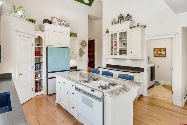 a kitchen with granite countertop a stove a table and chairs in it