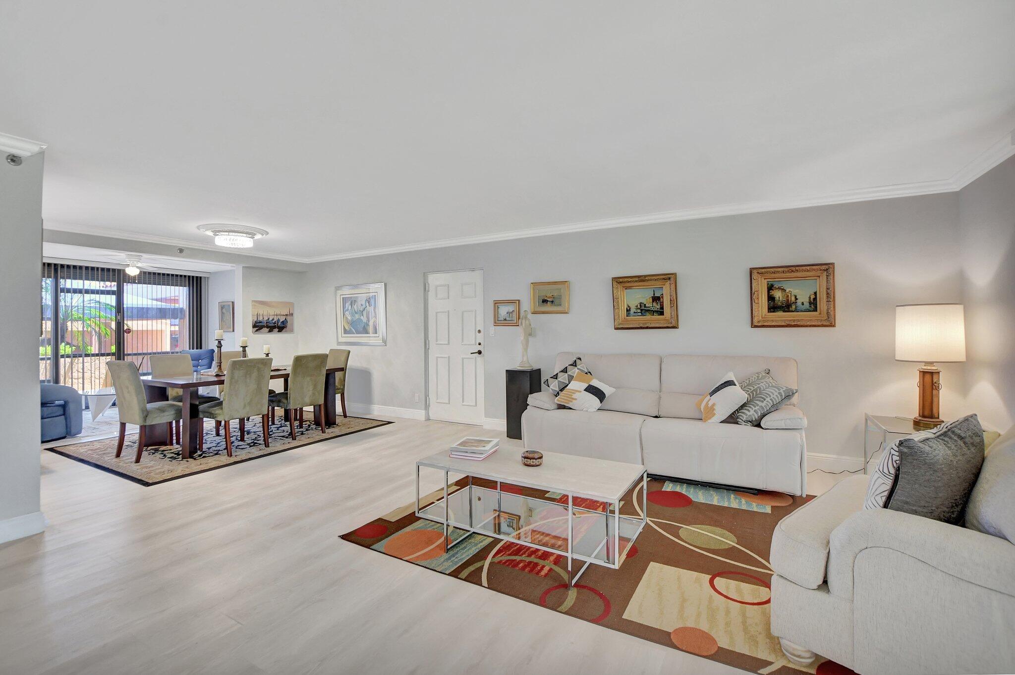 a living room with furniture and a dining table with kitchen view