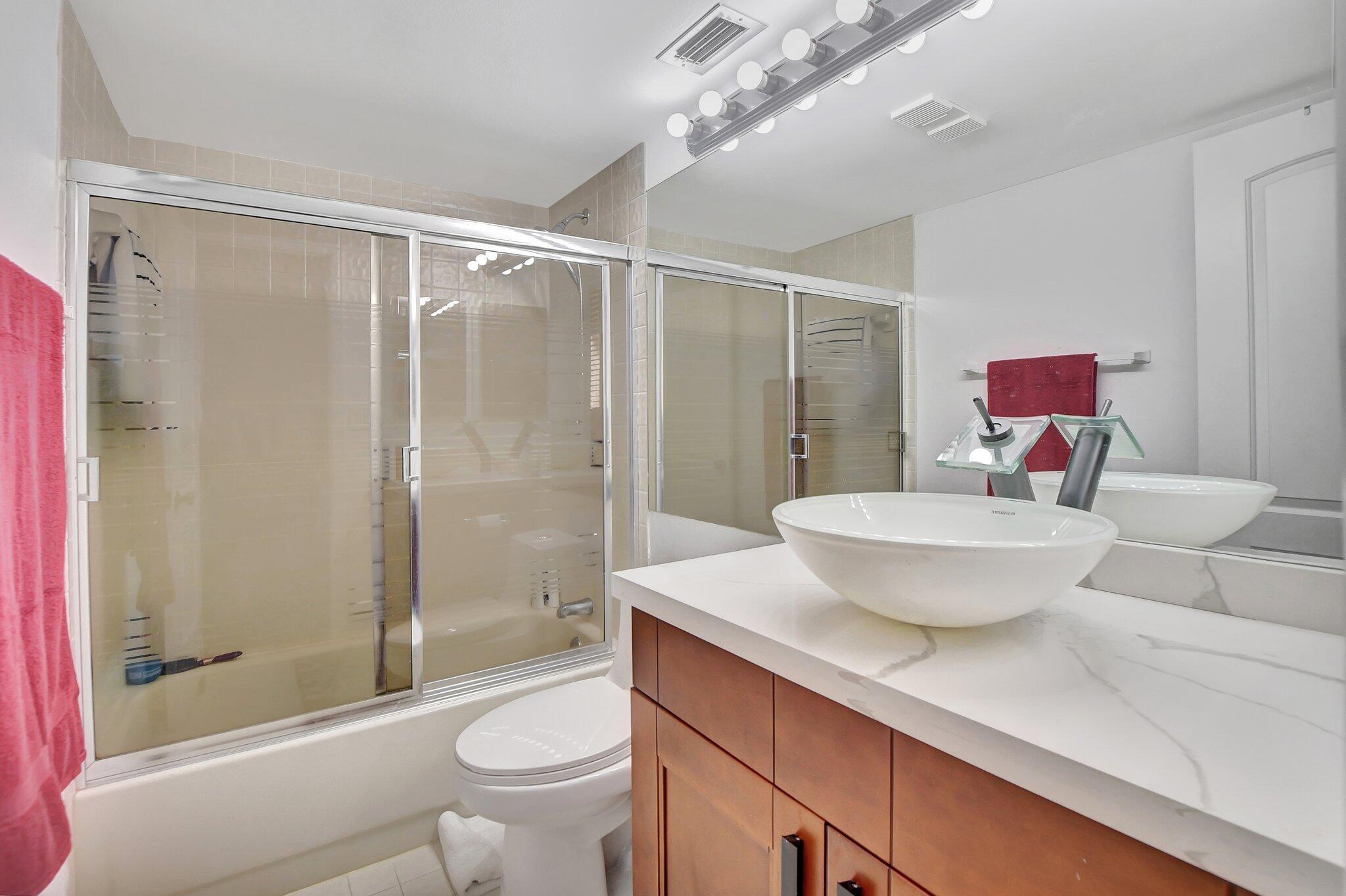 7194 Promenade Drive, Unit 102 Boca Raton, FL 33433 - Photo 23 of 56 a bathroom with a sink a toilet and shower