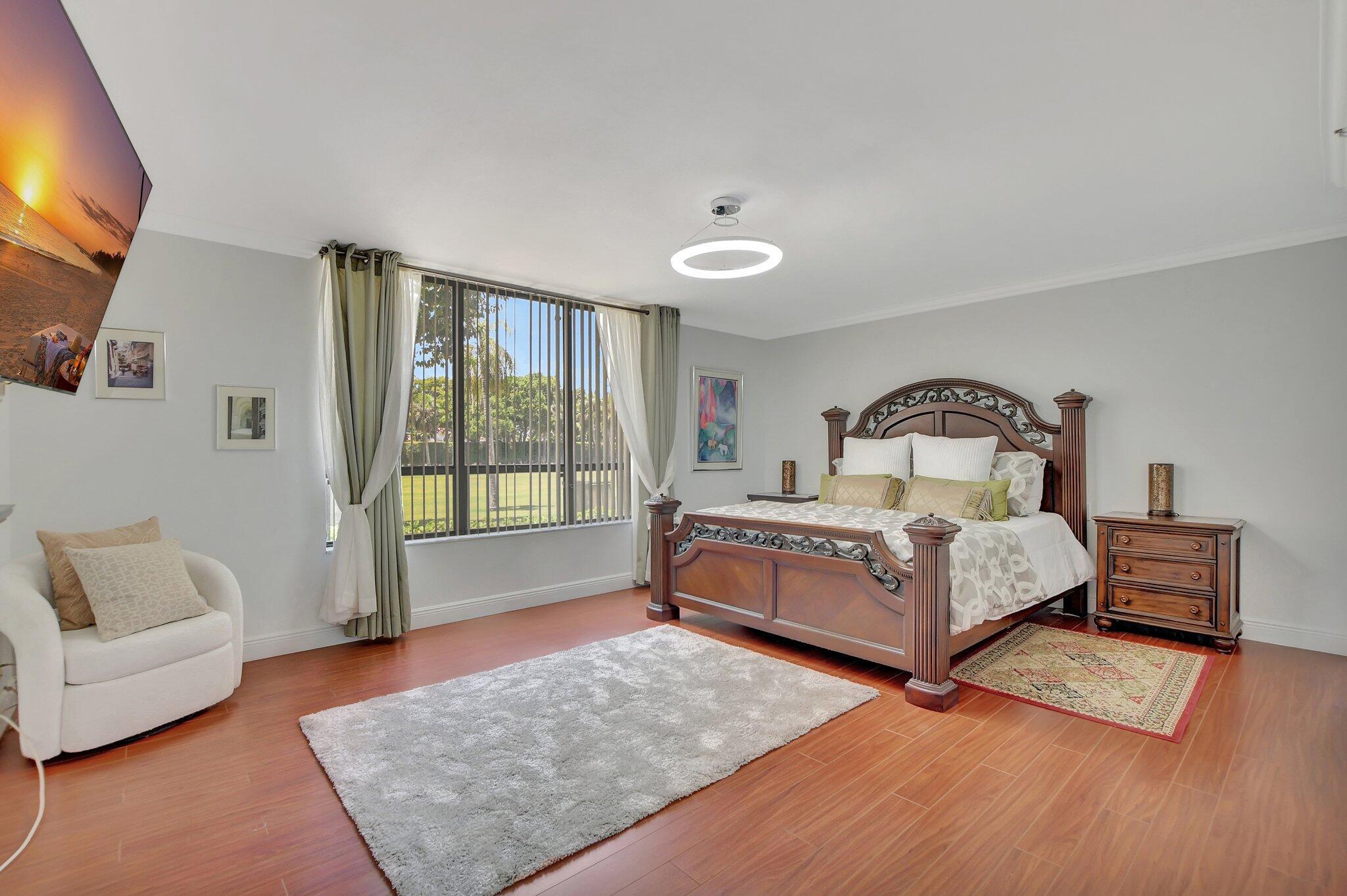 7194 Promenade Drive, Unit 102 Boca Raton, FL 33433 - Photo 25 of 56 a bedroom with a bed and a couch