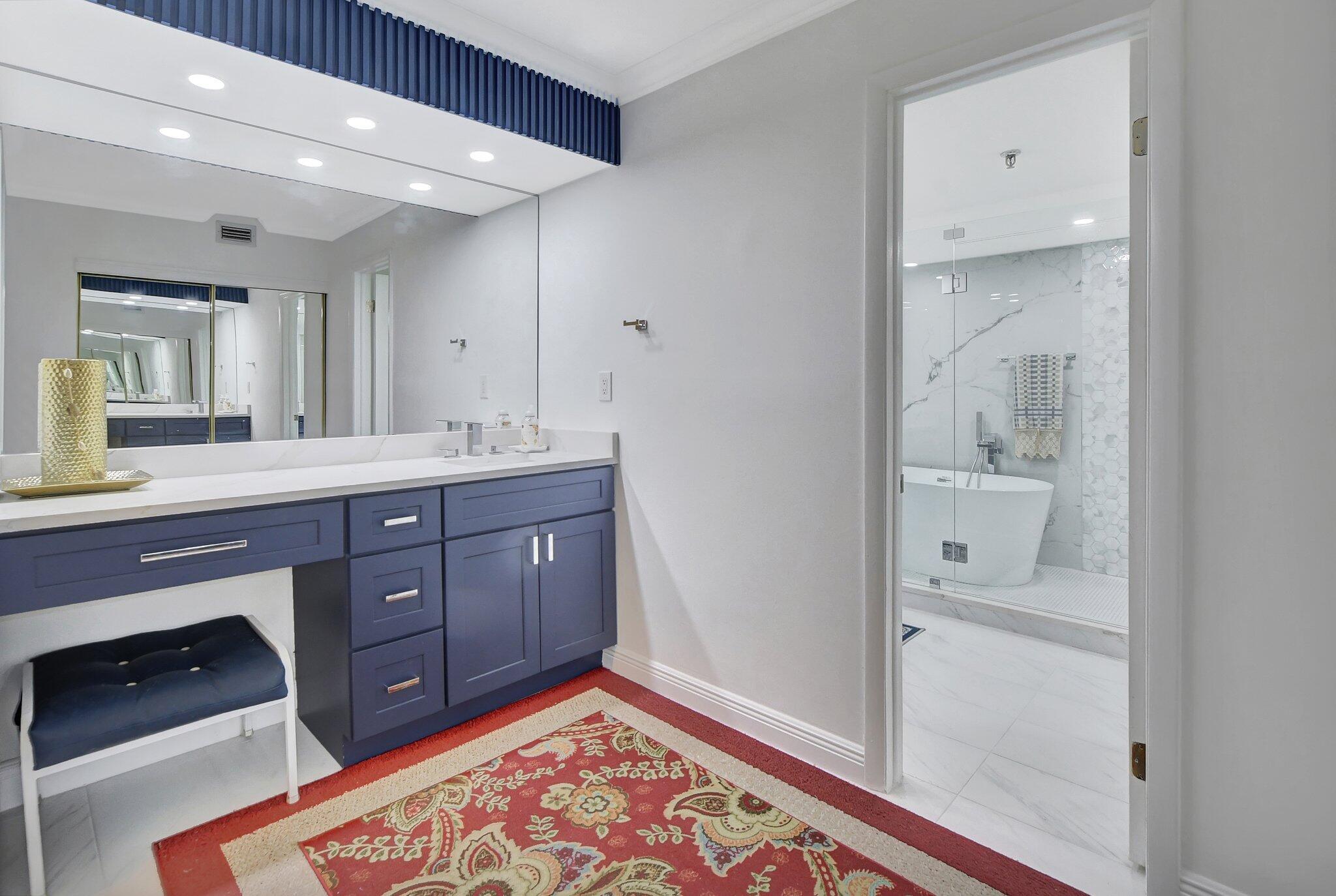 7194 Promenade Drive, Unit 102 Boca Raton, FL 33433 - Photo 28 of 56 a spacious bathroom with a double vanity sink a mirror and a bathtub