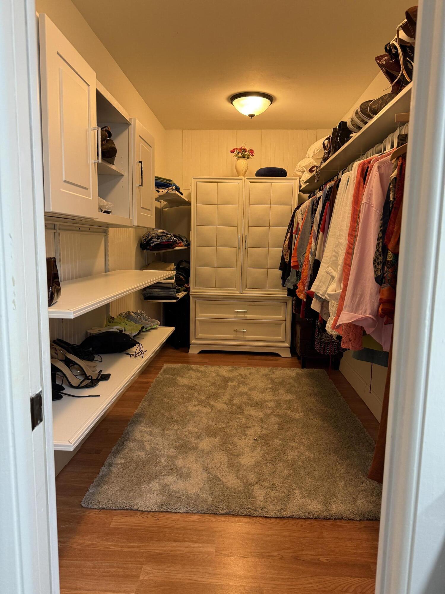 7194 Promenade Drive, Unit 102 Boca Raton, FL 33433 - Photo 33 of 56 a view of walk in closet with clothes and shoes