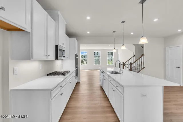 a kitchen with white cabinets and sink