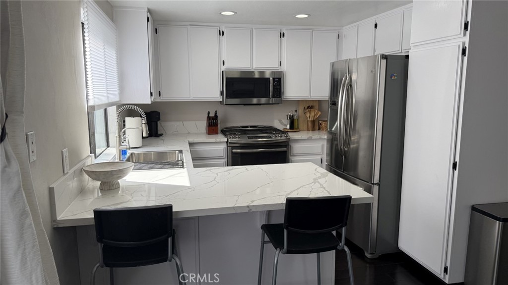 11300 Foothill Boulevard, Unit 33 Lakeview Terrace, CA 91342 - Photo 5 of 19 a kitchen with stainless steel appliances a stove refrigerator sink and cabinets