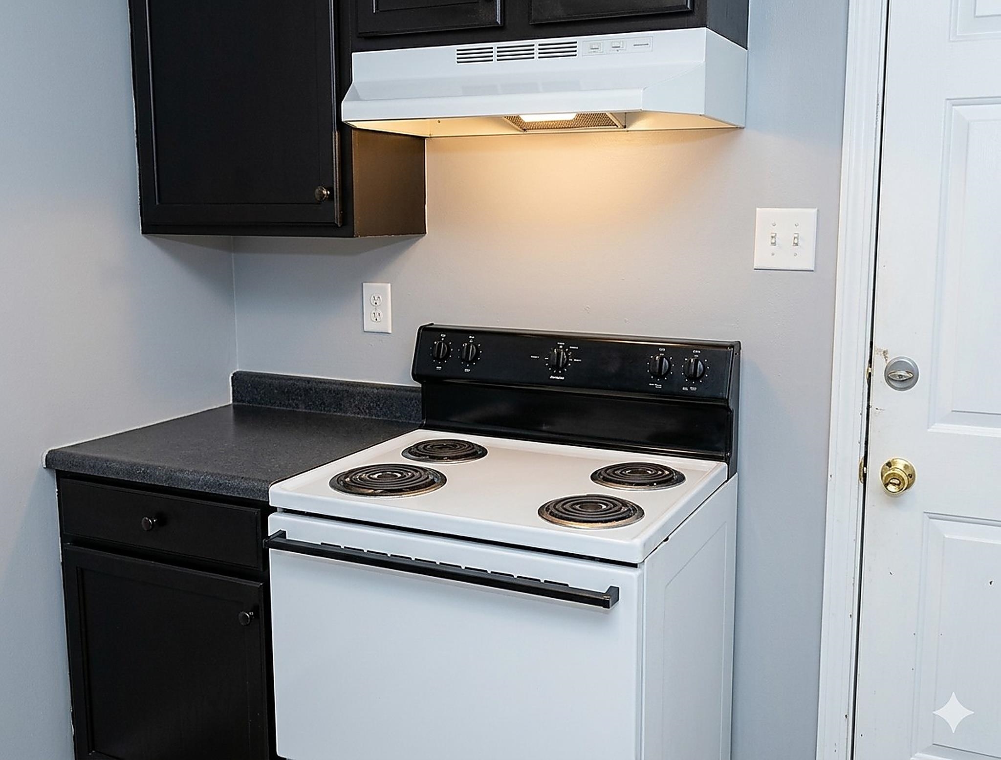 4444-4446 Sumners Wells Road Memphis, TN 38118 - Photo 6 of 8 Kitchen area featuring a white electric range with a black control panel, black cabinetry, and dark countertops
