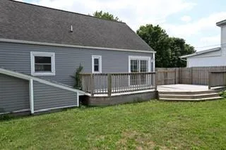 a view of a house with a backyard and a chair