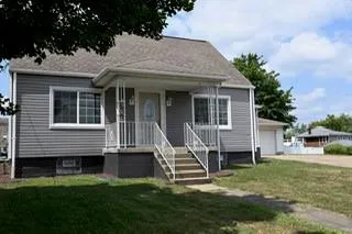 a view of a house with a yard and sitting area