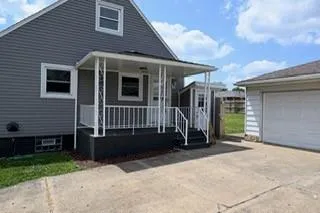 a view of a house with a yard and wooden fence