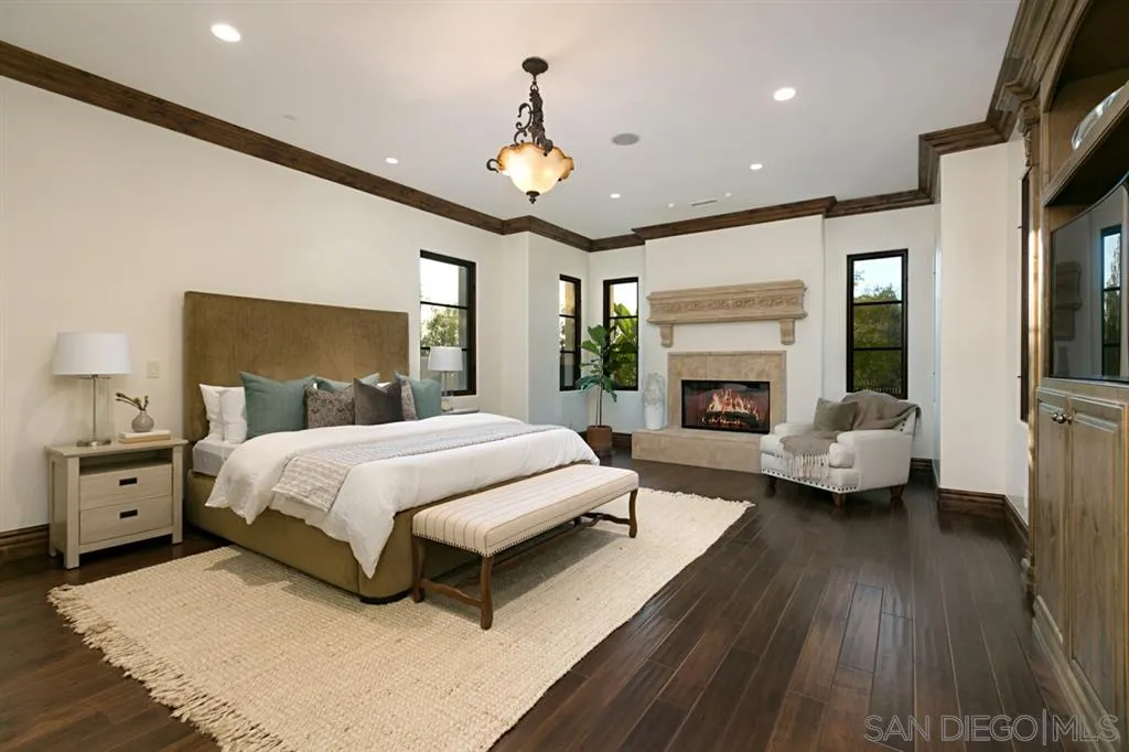 7620 Iluminado San Diego, CA 92127 - Photo 14 of 25 a spacious bedroom with a large bed and a fireplace