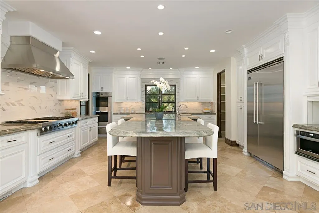 7620 Iluminado San Diego, CA 92127 - Photo 8 of 25 a kitchen with stainless steel appliances kitchen island granite countertop a stove and a refrigerator