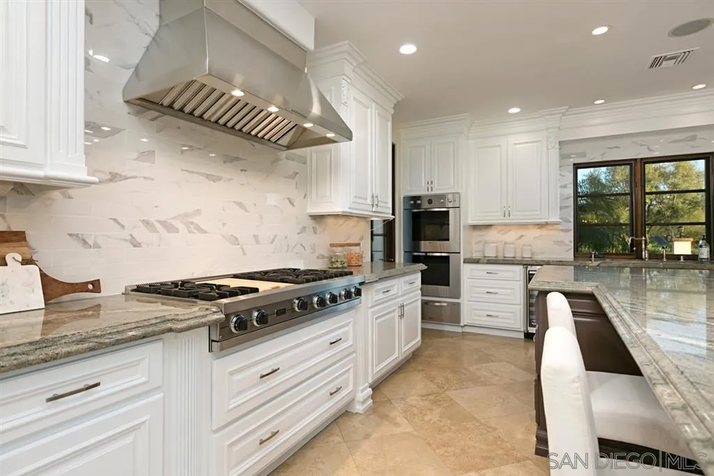 7620 Iluminado San Diego, CA 92127 - Photo 9 of 25 a kitchen with stainless steel appliances granite countertop a stove a sink and a microwave