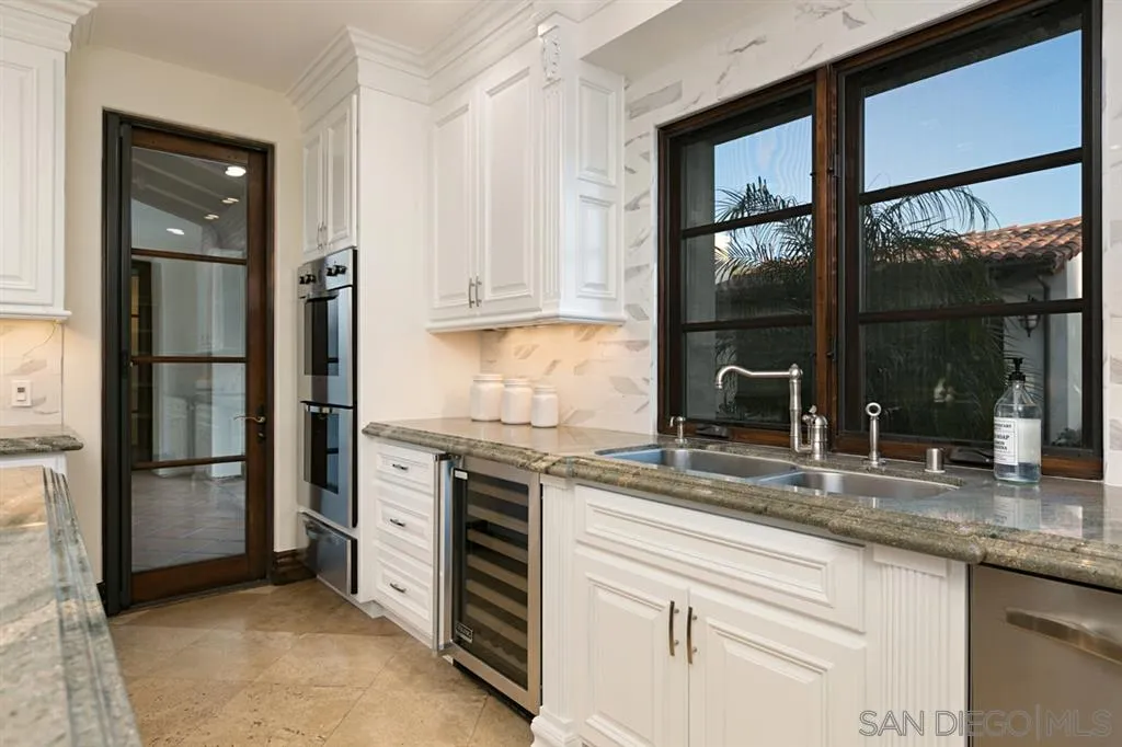 7620 Iluminado San Diego, CA 92127 - Photo 10 of 25 a kitchen with granite countertop a stove and a sink