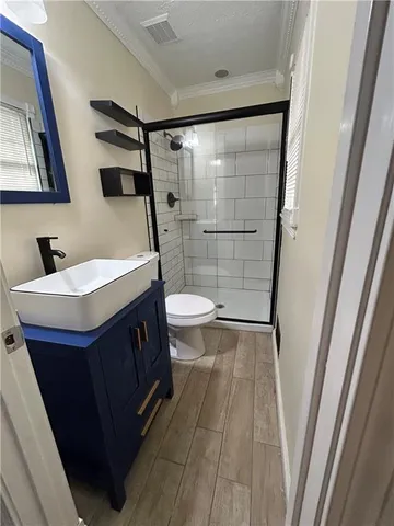 a bathroom with a sink a toilet a mirror and shower