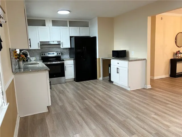 a kitchen with a refrigerator stove and wooden cabinets