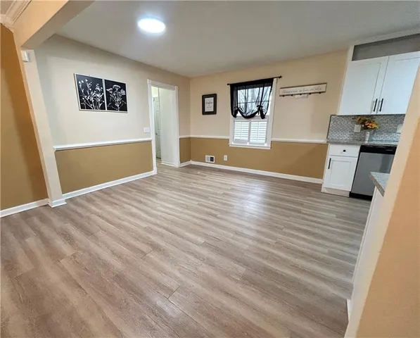 a view of a kitchen with wooden floor and a ceiling fan