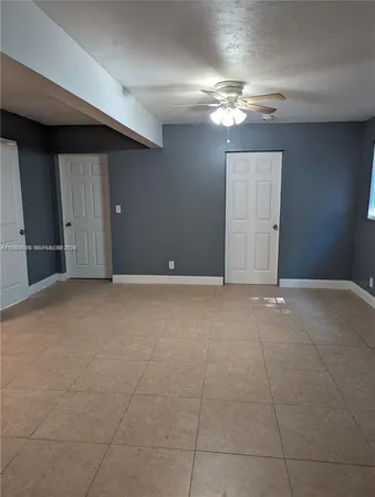 a view of an empty room with a chandelier fan