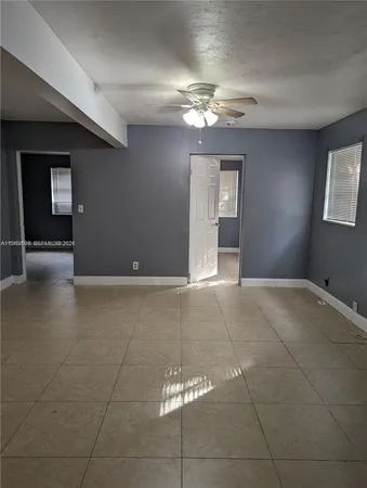 a view of an empty room with a chandelier fan