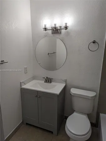 a bathroom with a toilet a sink and mirror