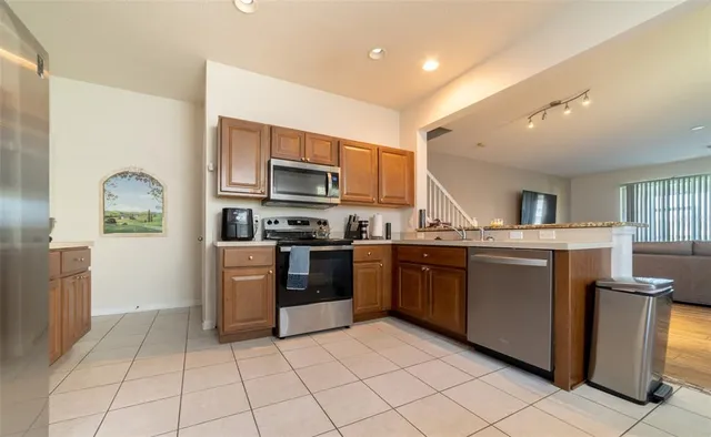a kitchen with stainless steel appliances granite countertop a refrigerator and a stove top oven