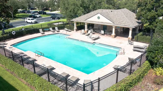 a view of a house with pool and chairs
