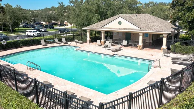 a view of a house with pool and chairs