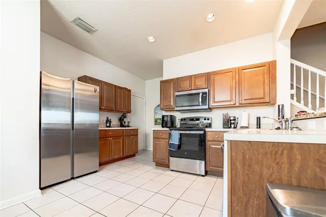 a kitchen with stainless steel appliances granite countertop a refrigerator a stove top oven a sink and dishwasher