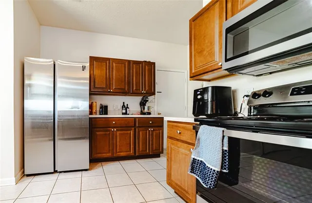 a kitchen with stainless steel appliances granite countertop a refrigerator a stove a sink and dishwasher
