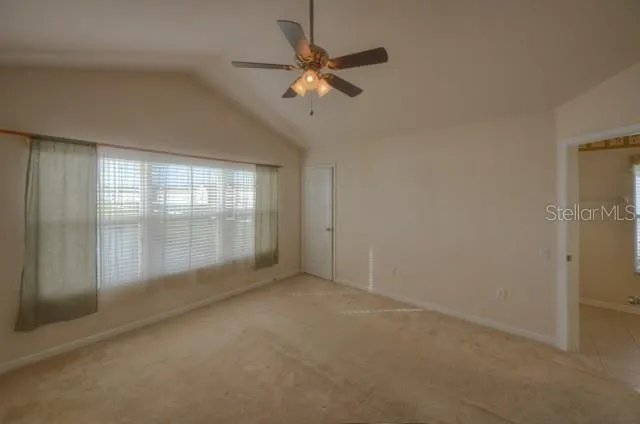 an empty room with a ceiling fan and window