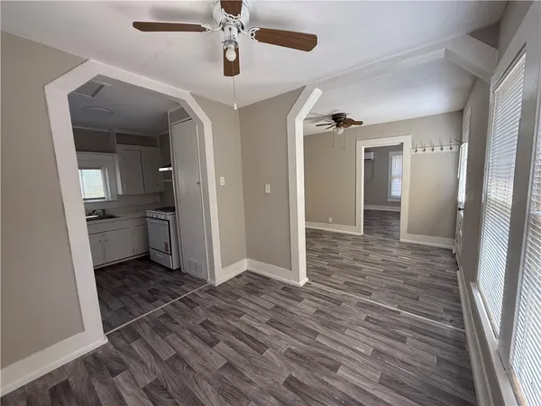 wooden floor in an empty room with a kitchen