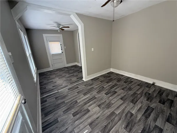 a view of a hallway with wooden floor and staircase